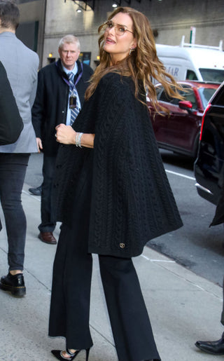 Brooke Shields arrives at the Stephen Colbert Show wearing a Dodiee Jumpsuit in noir with the cable-knit Cape Cardigan in noir